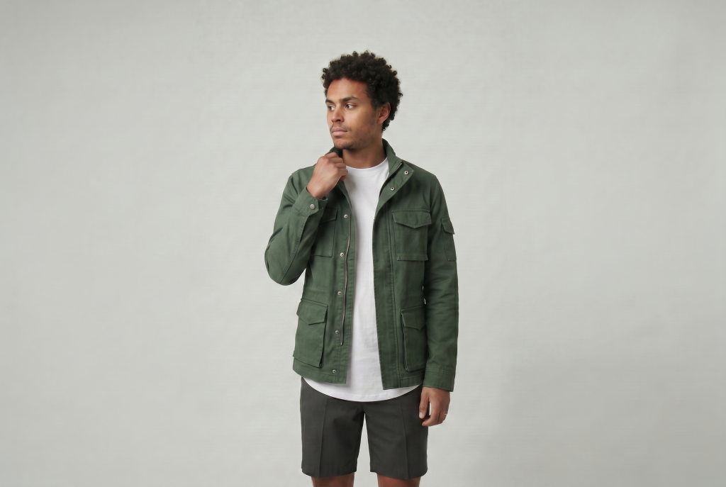Man in a layered green overshirt with a ten10 apparel white curved hem t-shirt underneath