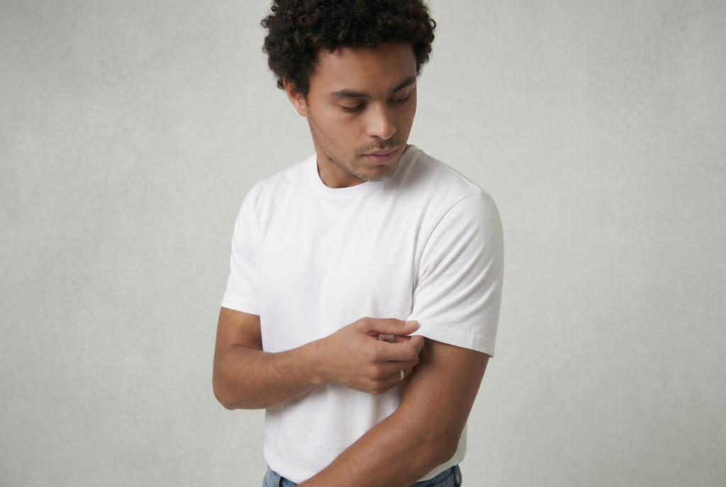 close up image of man holding the sleeve of his white shirt