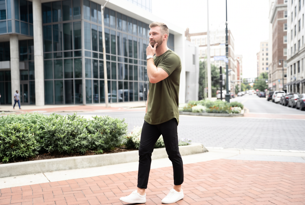 What is a dovetail shirt. Man walking in a green dovetail tee with black pants on