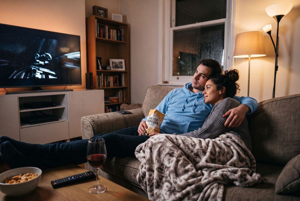 man on the couch with a light blue hoodie