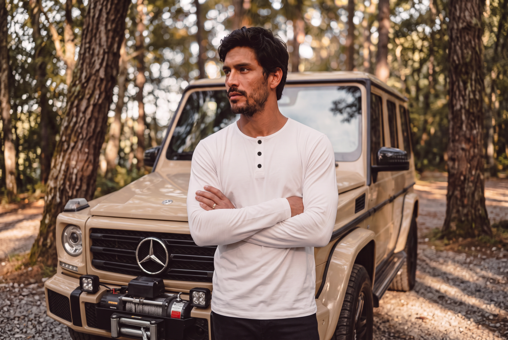 Man in transition weather white long sleeve standing in the woods